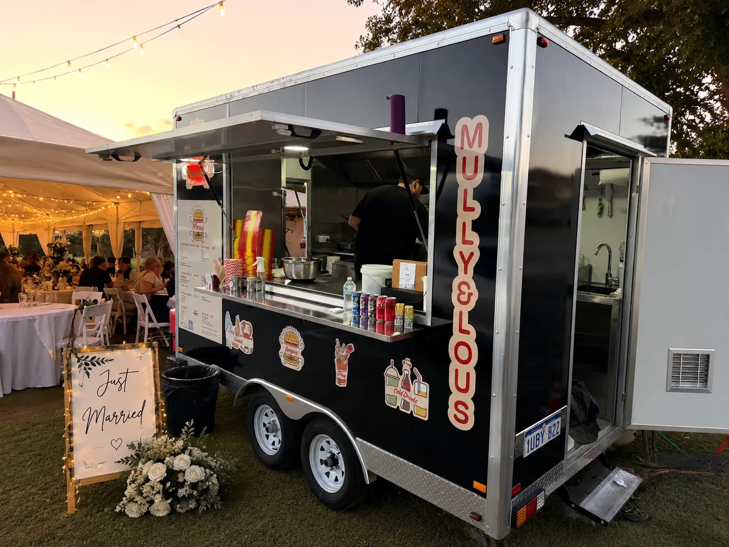 The Mully & Lou's van set up at a wedding beside a Just Married sign and festoon lights