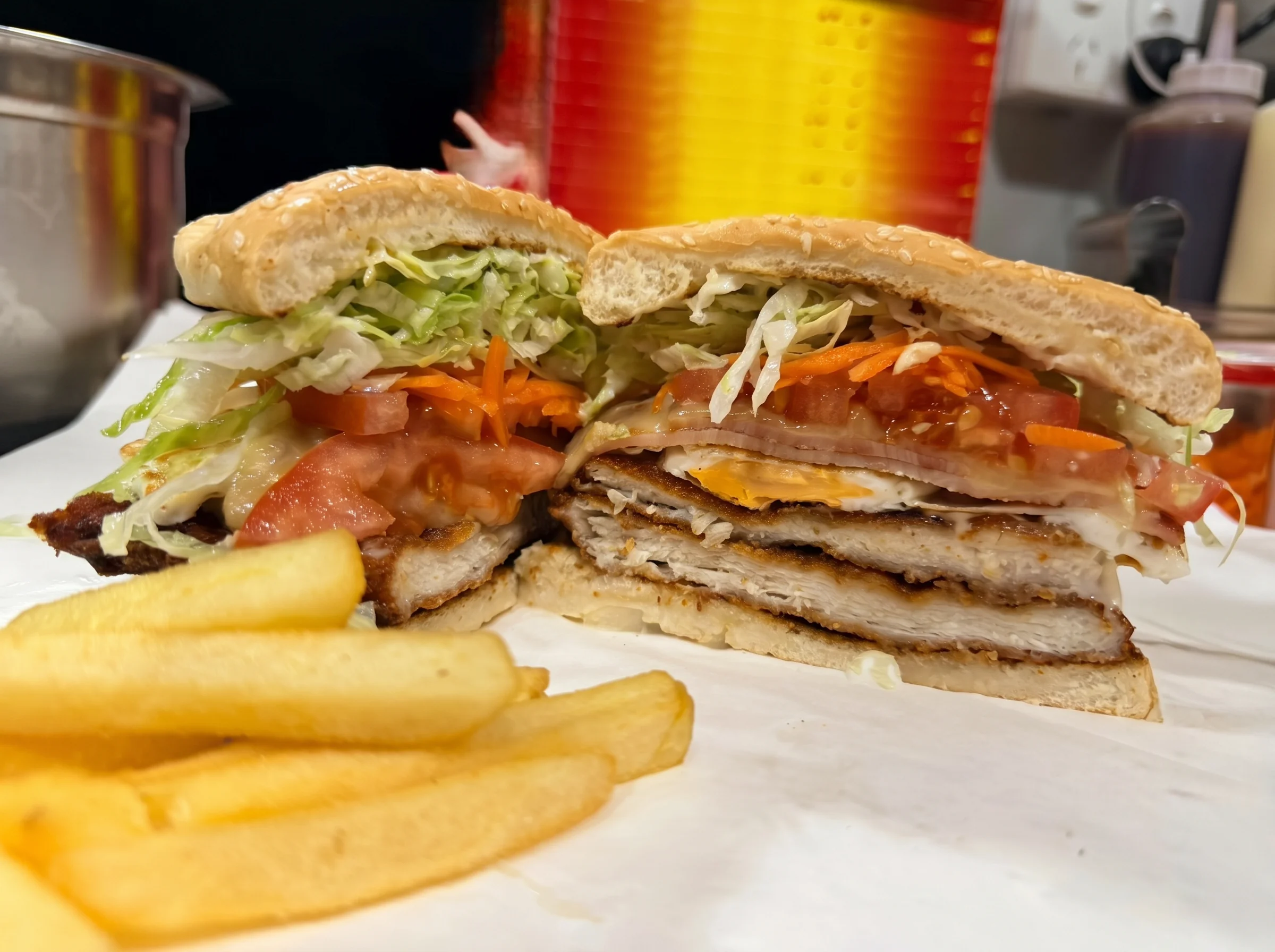 Layered chicken schnitzel burger with chips